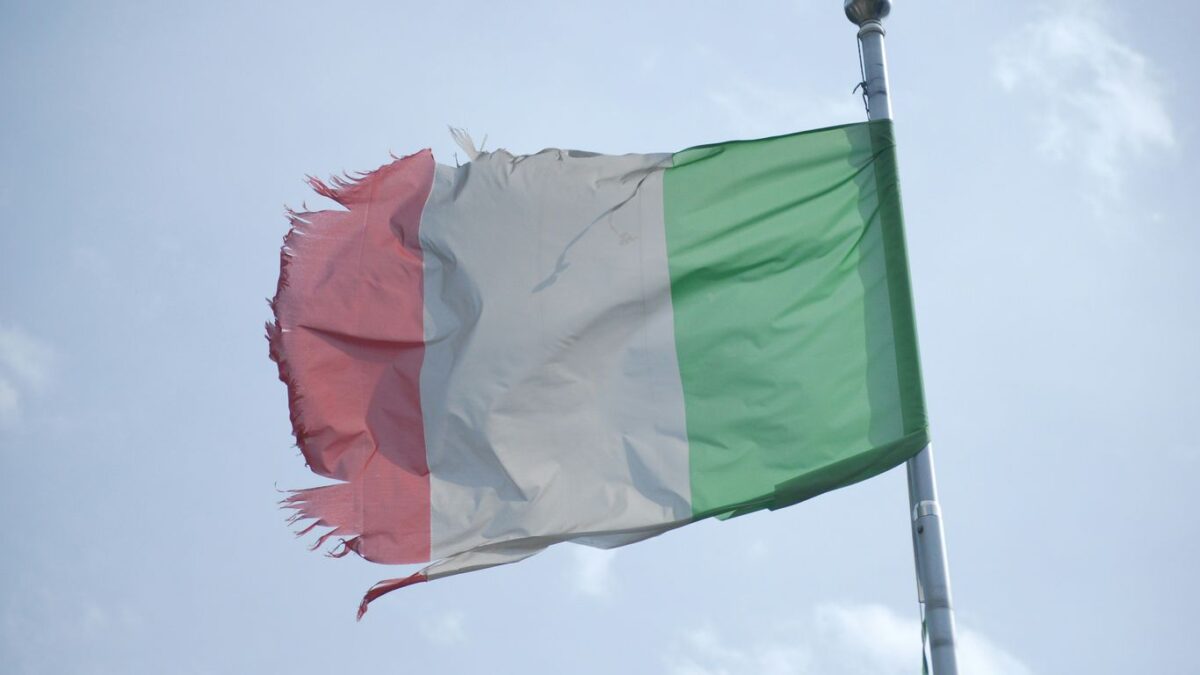 a flag flying in the wind with a sky background