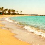Ruhiger Strand auf Lido di Venezia mit goldenem Sand und türkisfarbenem Wasser.