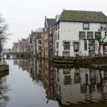 Canal lined with buildings and reflections in water.