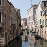 boat on river between buildings during daytime