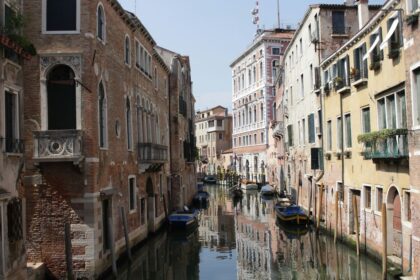 boat on river between buildings during daytime