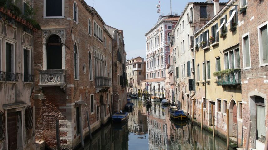 boat on river between buildings during daytime