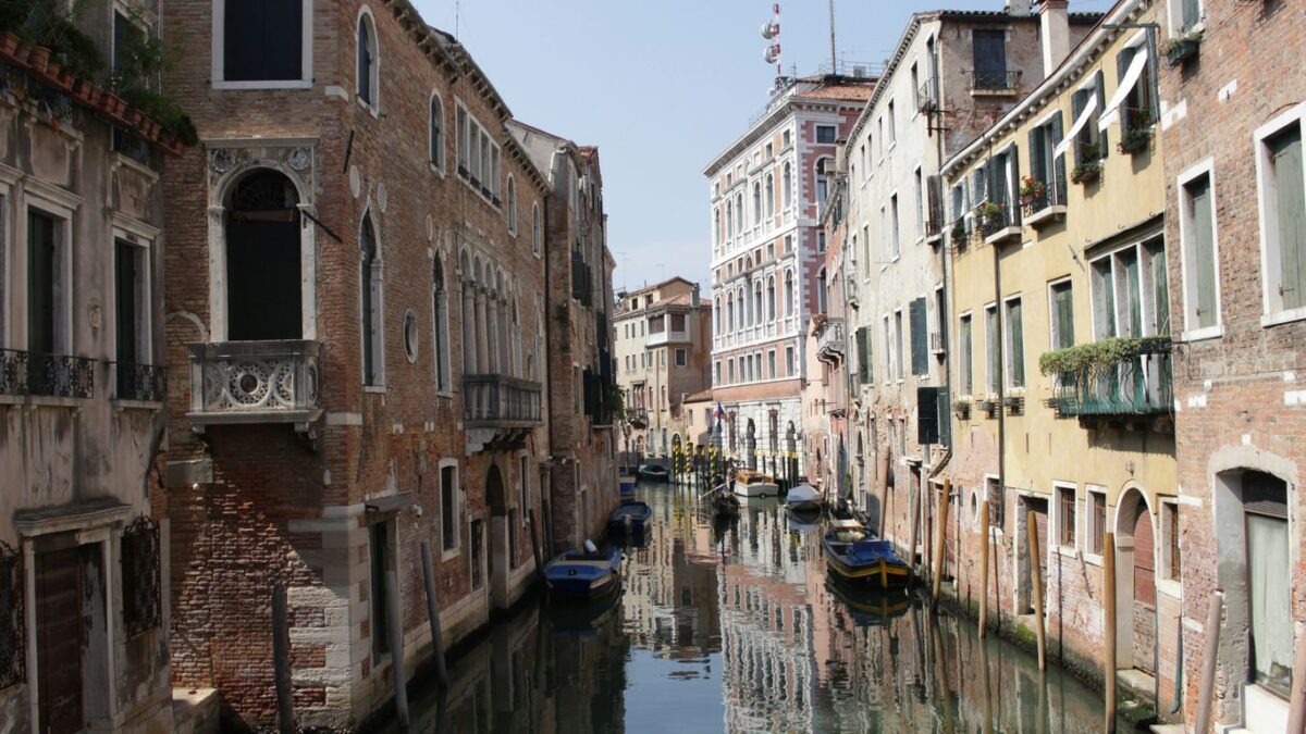 boat on river between buildings during daytime