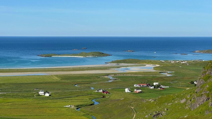 Coastal village nestled in green fields by the ocean.