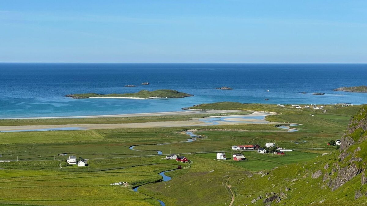 Coastal village nestled in green fields by the ocean.