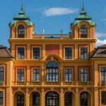 a large orange and yellow building with two towers