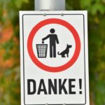 a street sign with a dog and a man in a basket