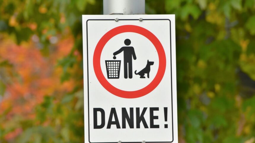 a street sign with a dog and a man in a basket